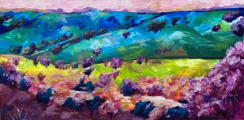 A multicoloured view of hills, trees and a river, in blues, greens, yellows, pinks and purples.