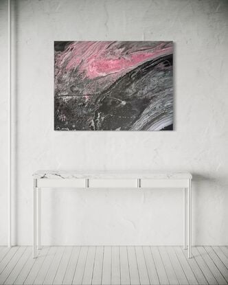 A fluid art painting featuring swirling patterns of black, grey, and pink acrylic paint on canvas. The composition resembles a flowing, abstract landscape with a dynamic contrast between dark and light tones, evoking a sense of movement and depth.