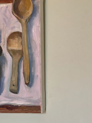 The painting depicts a collection of wooden kitchen spoons on a cloth with a kitchen carving fork.
I can be read as a metaphor for the odd one out or danger.