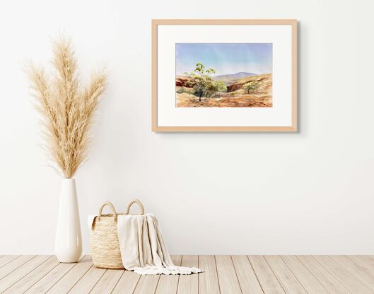 Red gorge, golden country, sparse gum trees, clear sky, distant ranges. Vast landscape