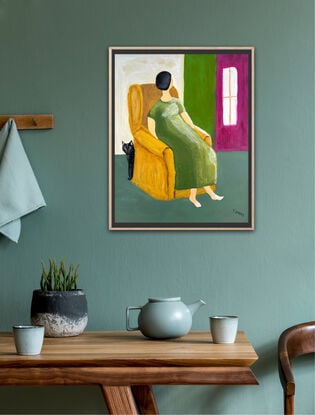 Interior abstract style painting of a lady or woman with short black hair with no features on her face, wearing a long green dress sitting in an ochre coloured wingback chair. There is a black cat peeking around from the back of the armchair. The walls behind alternate from creamy white to green to magenta. There is a white window in the magenta wall. The lady has bare feet. The floor is a  grey green colour. 