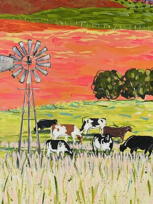 A group of cows grazing under a windmill in a bright landscape.