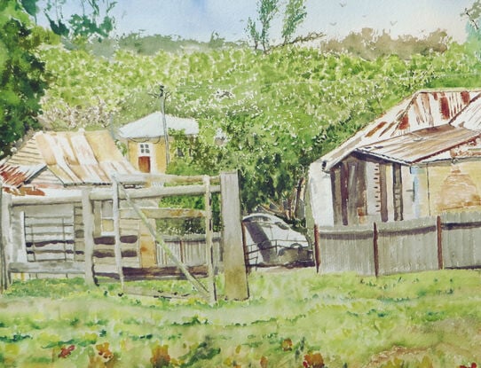 from a back street one can see a couple of old cottages with rusty tin roofs and washing hanging from the line, gardens enclosed by timber palings and large fence posts with an array of grasses, dirt mounds and in the far background the many shrubs and trees the Australian bush surrounding this quaint village of Berrima in the Southern Highlands