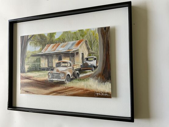 Australian Outback and two rusty old Ute’s  and house underneath the gumtrees.