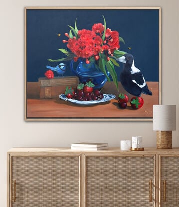 Magpie and fairywren on a tabletop with gum blossom and cookbooks and fruit. 