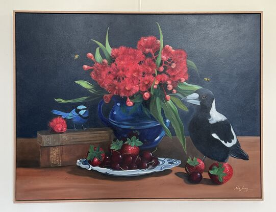 Magpie and fairywren on a tabletop with gum blossom and cookbooks and fruit. 