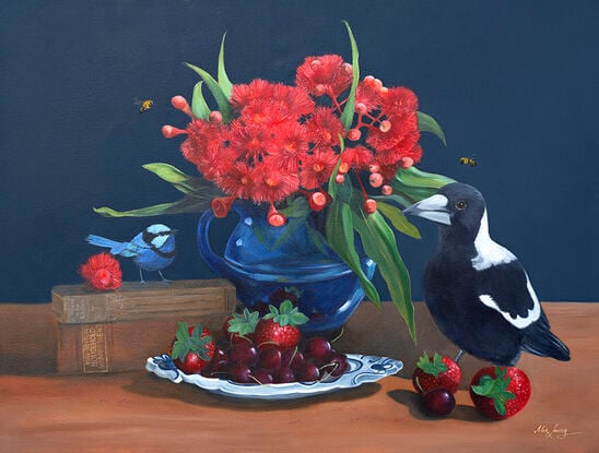 Magpie and fairywren on a tabletop with gum blossom and cookbooks and fruit. 