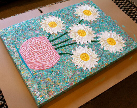 white and yellow textured flowers in a pink vase on a sky blue background