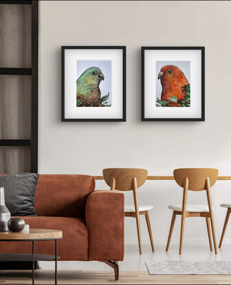 Portrait of red and green parrot with brown branches and green leaves crossing the lower quarter of the paper.