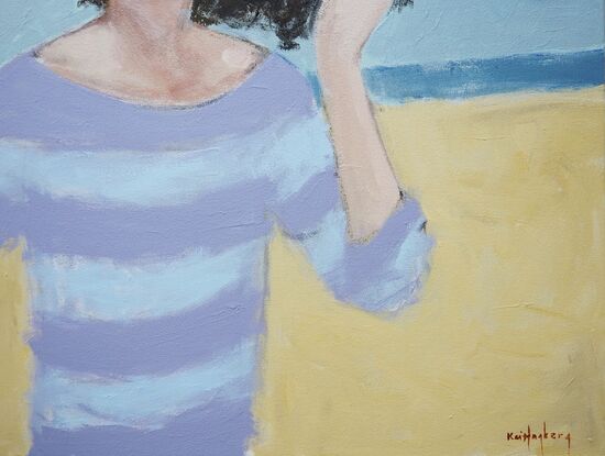 Woman on the beach, her hair blown by wind