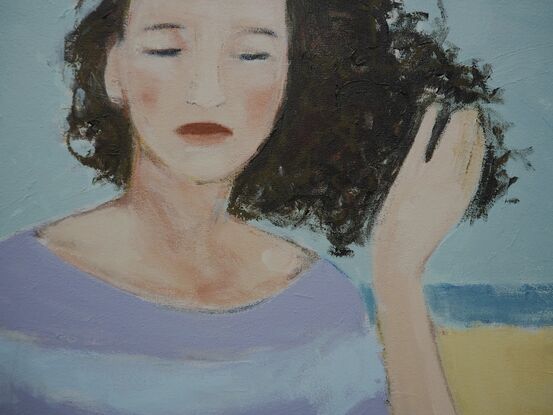 Woman on the beach, her hair blown by wind