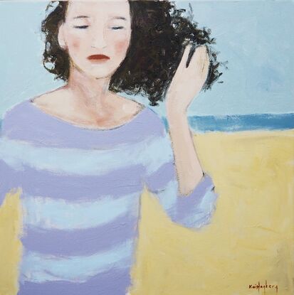 Woman on the beach, her hair blown by wind