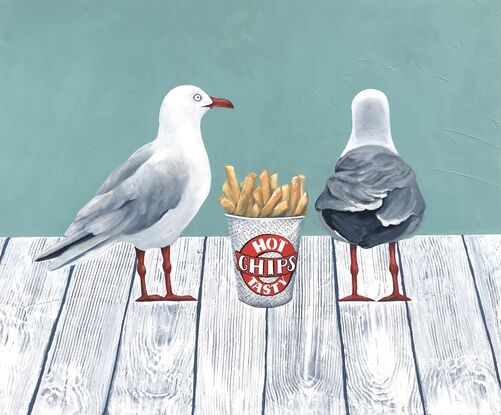 Two sea gulls standing on a white wooden jetty with a cup of hot chips between them.