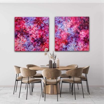 This listing is for a diptych. It's in various shades of pink, purple, and red.  It's an abstract, with patches of bright colours floating around the canvas