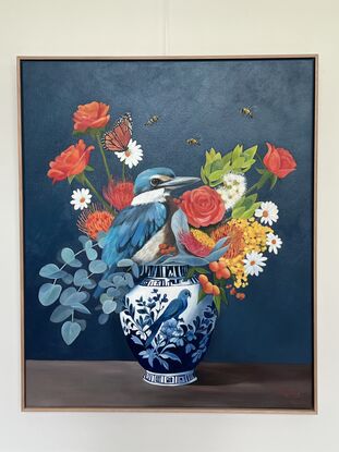 Sacred Kingfisher perched on a chinoserie vase filled with flowers. 