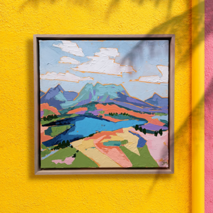 A colourful, segmented square painting depicting Cradle Mountain in blues and purples. A lake is seen in the foreground.