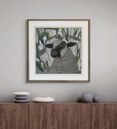 A framed mixed media drawing of a Sheep and a Little Brown Bird amongst eucalyptus on 360 gsm pastel paper, rendered in coloured pencil and oil pastel