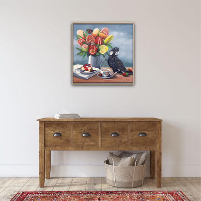 Carnaby's Cockatoo and banksias and cake on a table top. 