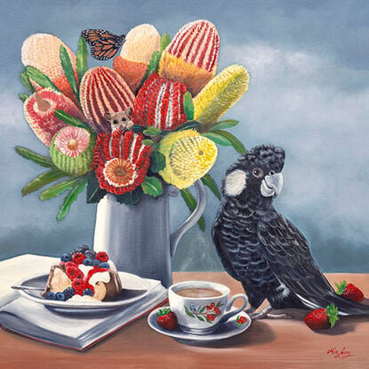 Carnaby's Cockatoo and banksias and cake on a table top. 