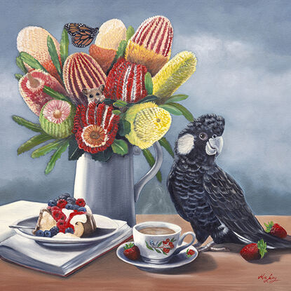 Carnaby's Cockatoo and banksias and cake on a table top. 