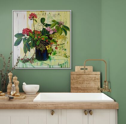 A framed limited edition canvas print in a white wood floating frame of an original still life painting of flowers in yellows, greens , reds and oranges in a glass vase