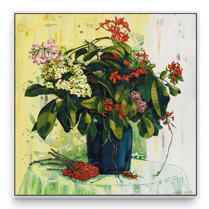 A framed limited edition canvas print in a white wood floating frame of an original still life painting of flowers in yellows, greens , reds and oranges in a glass vase