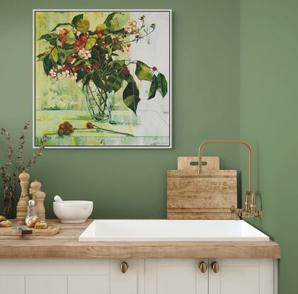 A framed limited edition canvas print in a white wood floating frame of an original still life painting of flowers in yellows, greens , reds and oranges in a glass vase