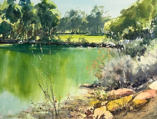 A view of a lake in Yallingup with reflections of trees on a sunny day.