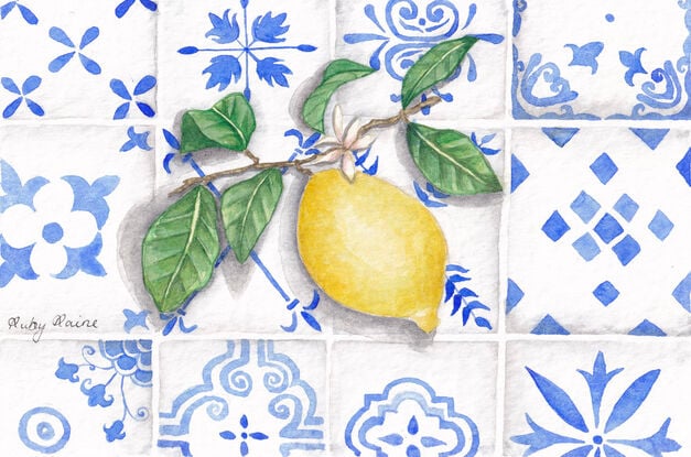 a branch with a lemon resting on Mediterranean-style tiles