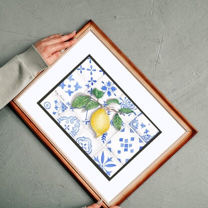 a branch with a lemon resting on Mediterranean-style tiles