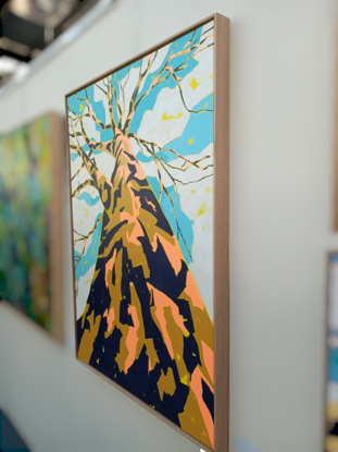 A gum tree in yellow, mustard and navy, with a blue sky and clouds above the crown