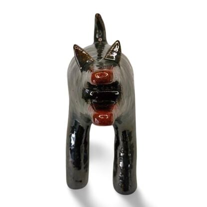 The "Raku Beast" is a striking ceramic sculpture with a glossy, dark Raku glaze that captures the untamed essence of a wild, howling creature. 
Freestanding, signed on back