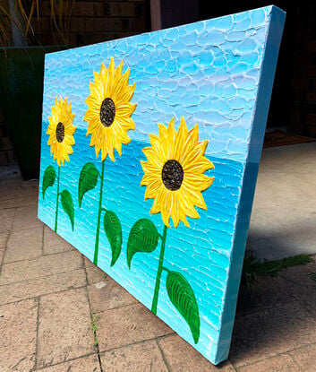 yellow textured thick paint palette knife sunflowers on a coastal water blue background