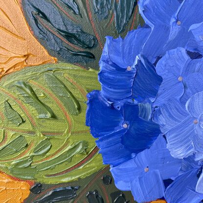 3 purple-blue hydrangeas in a light pink vase on a warm orange background. 