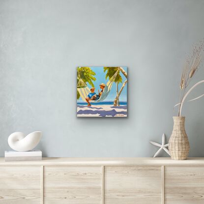 Two boys in a hammock on the beach with palm trees and ocean 