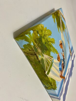 Two boys in a hammock on the beach with palm trees and ocean 