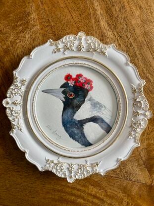 Magpie with a flower crown in an ornate white and gold frame. 