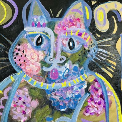 A sitting cat with hydrangea flowers in purple and blue and pink