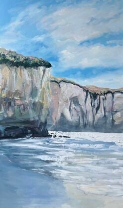 Seascape with beach and tall cliffs.