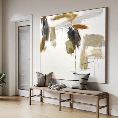 bold paint and pencil marks in light ochre with areas of white and grey, beige, tan, and navy blue expressive marks across a large canvas