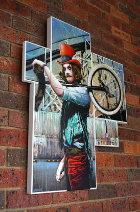 A busking clown with a unicycle walks in front of an amusement park