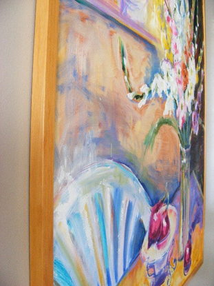 Various colored Gladioli in a clear vase , red onions in a clear glass bowl, and a painting is hanging on the wall