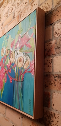 Pink gum flowers in a vase with blue background