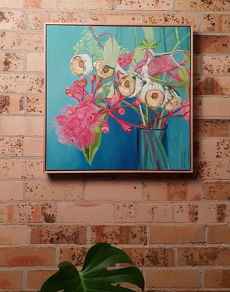 Pink gum flowers in a vase with blue background