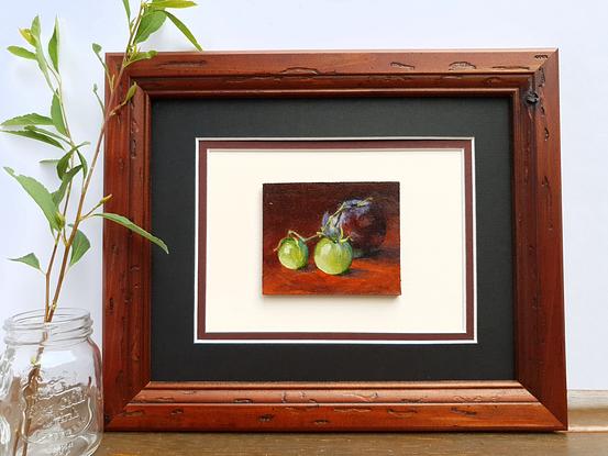 Still life of dark plum with green cherry tomatoes