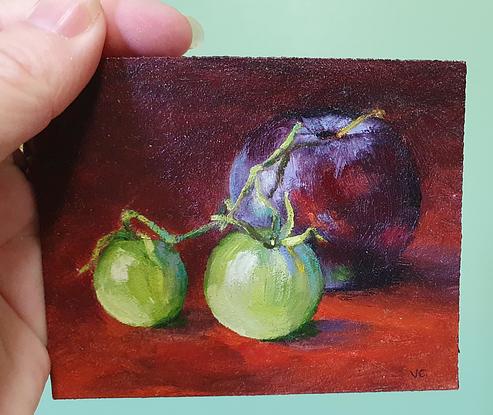 Still life of dark plum with green cherry tomatoes