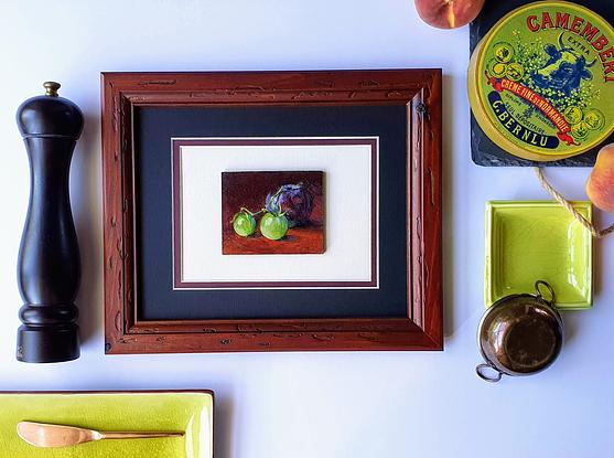 Still life of dark plum with green cherry tomatoes