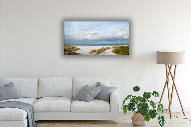 Blue sky, white clouds, blue water, white sand, and green grasses.