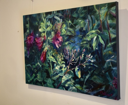 Horizontal painting of  red Hollyhock  flowers and old fashioned rose buds and a blue pond.   In a garden setting with  glimpses of a pond and a dark background