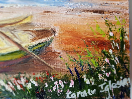 Evening at Sunset Beach in Port Stephens. A yellow and red boat on the sand. Greenery and wild flowers in the foreground. Lots of sailing boats on the water. Point Restaurant and The Boat Shed in the distance. The sky is dark blue and pink. The sand is pinkish.  